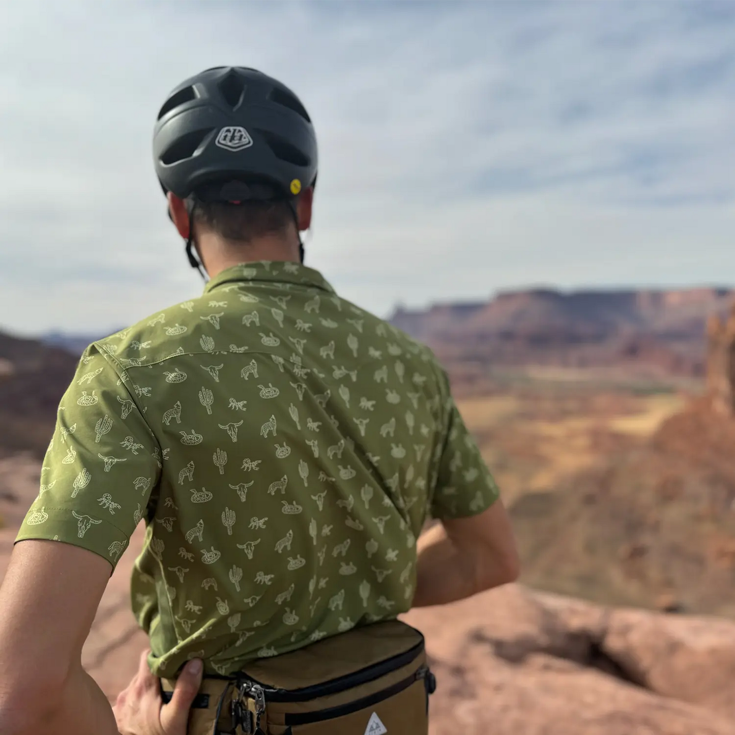 Model wearing badland breeze in moss, looking at the whole enchilada trail